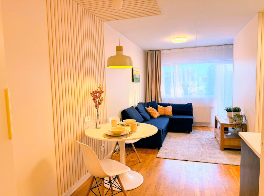 Kaasaegne minimalistlik elutuba koos söögialaga, heledates toonides sisekujundus ja puidust detailid